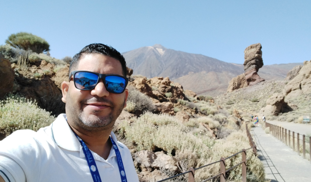 Persoon met een zonnebril in Nationaal Park Teide, Tenerife. Berg- en rotsformatie erachter.
