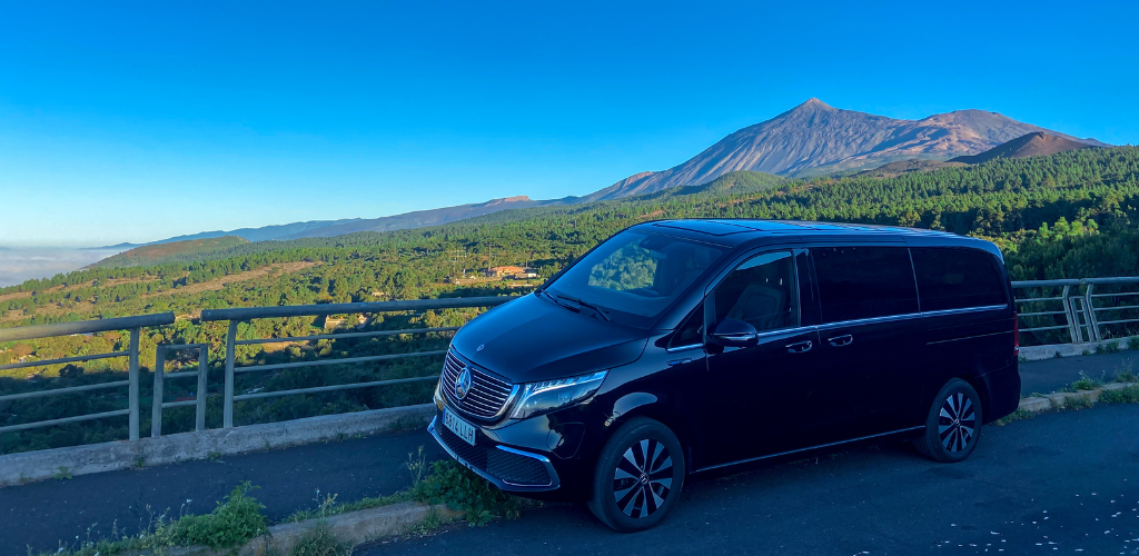 Zwart voertuig met Teide-achtergrond op Tenerife onder een heldere lucht.