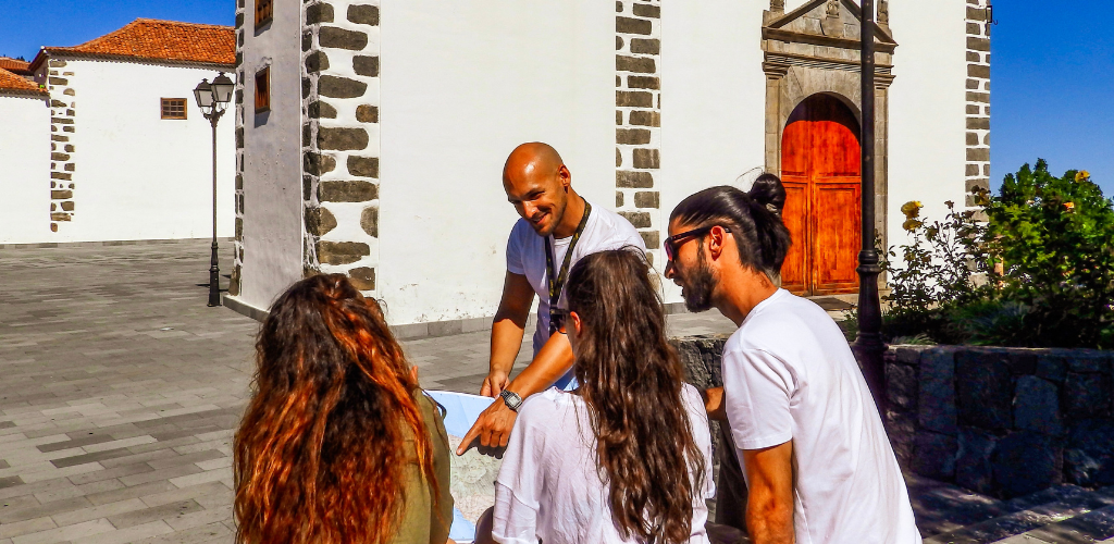 Groep mensen kijkt naar een kaart voor een kerk in La Laguna, Tenerife.