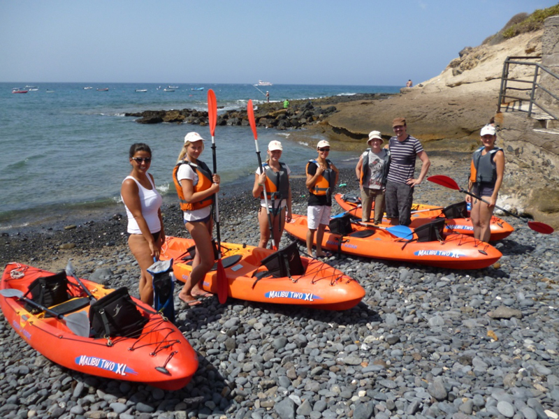 Groep met kajaks op het strand van Tenerife, klaar voor een excursie.