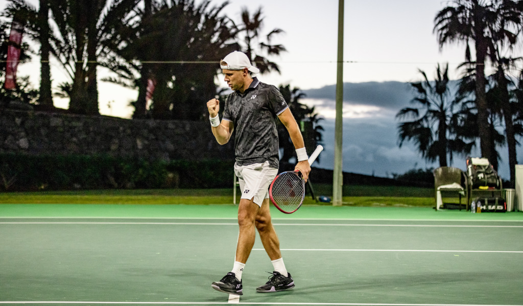 Tennisser viert op de buitenbaan op Tenerife bij zonsondergang.