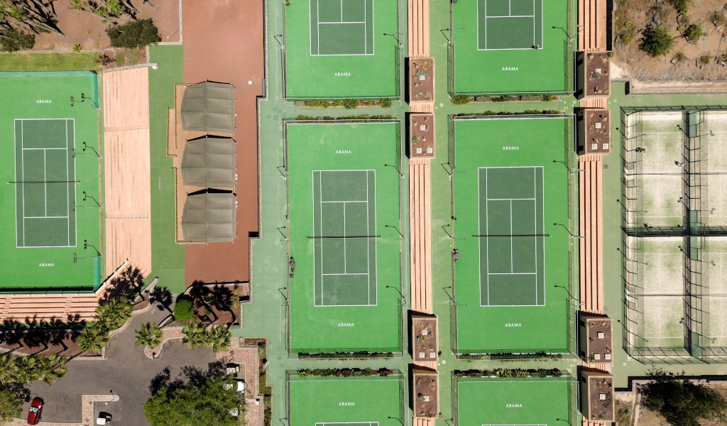 Luchtfoto van tennisbanen in Abama, Tenerife, omgeven door groen en rustplaatsen.