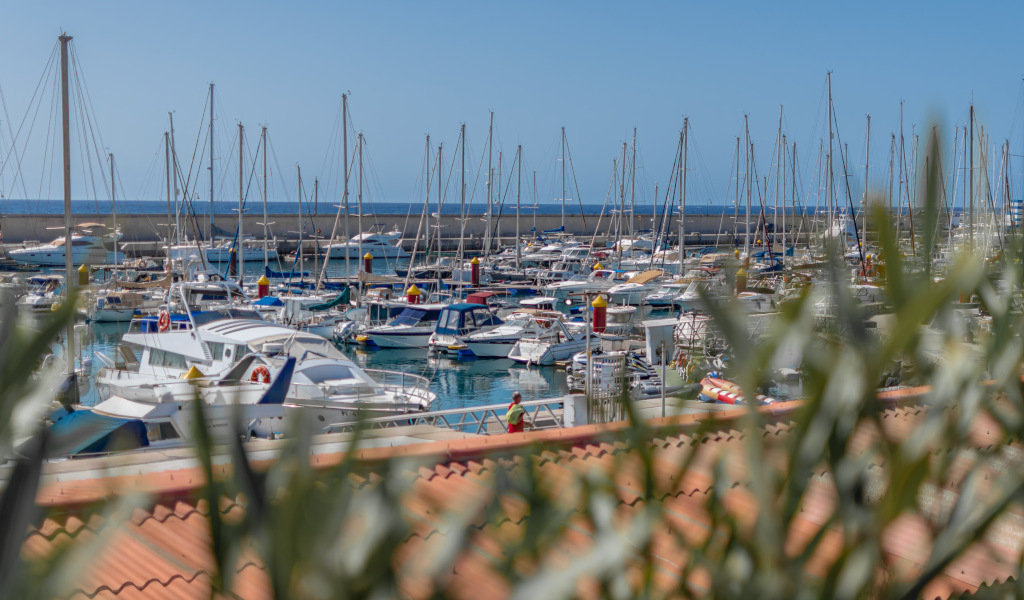 Boten lagen afgemeerd in de haven van Los Cristianos, Tenerife, met de zee op de achtergrond.