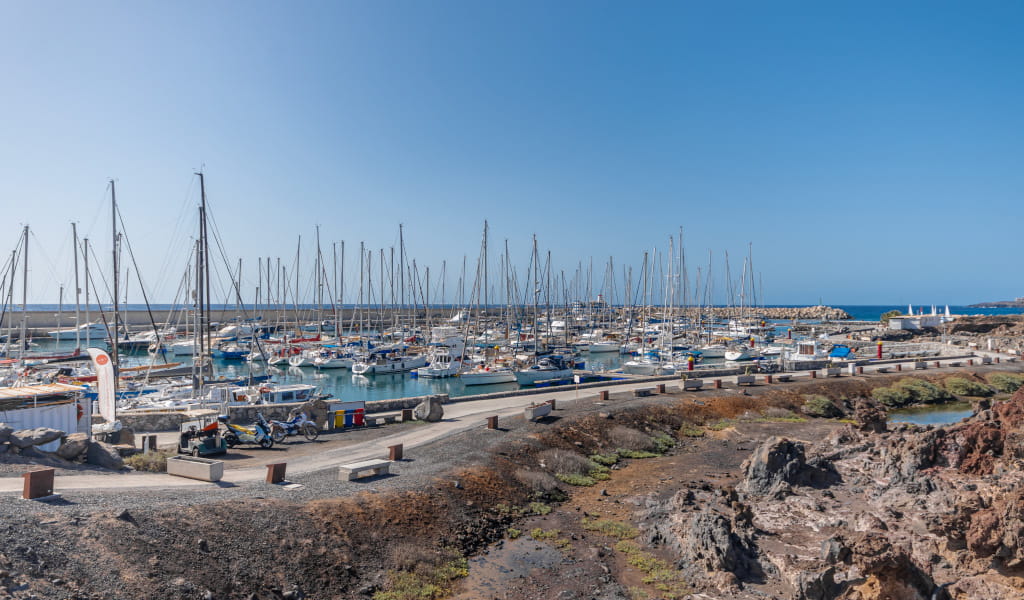 De haven van Los Gigantes op Tenerife met aangemeerde boten en blauwe zee.