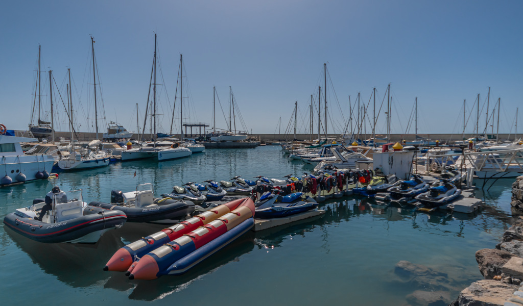 Jetski's en boten lagen aangemeerd in de haven van Tenerife.