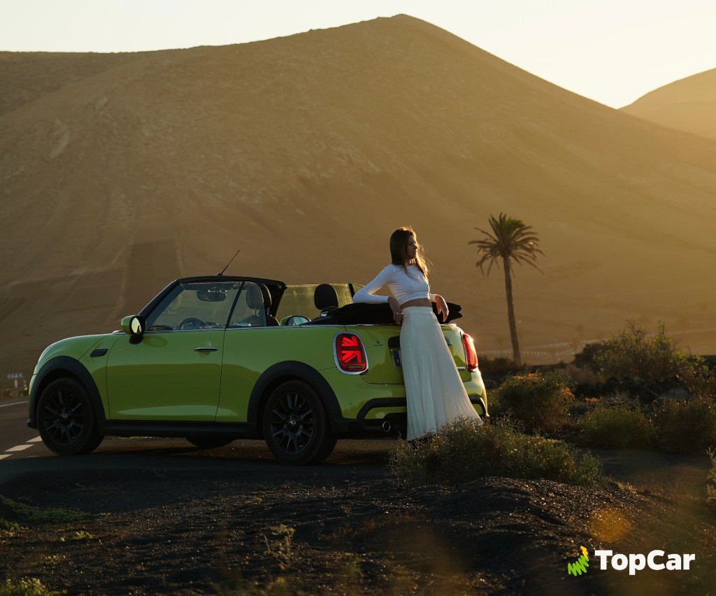 Groene cabriolet met persoon voor het bergachtige landschap op Tenerife.