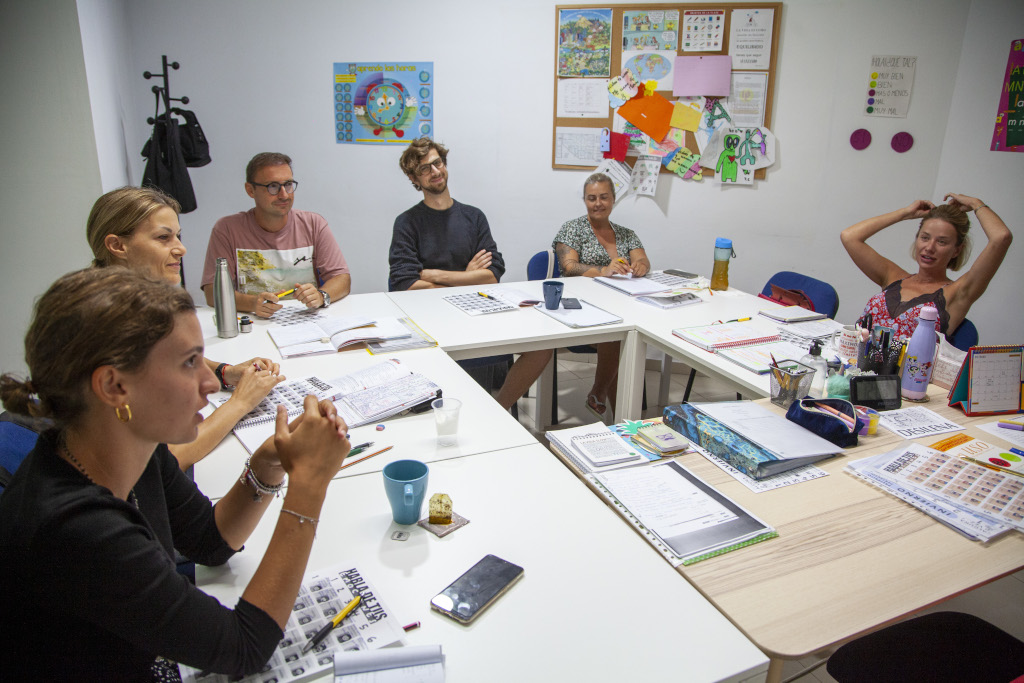 Groep mensen aan een werktafel in een schoolklas op Tenerife.