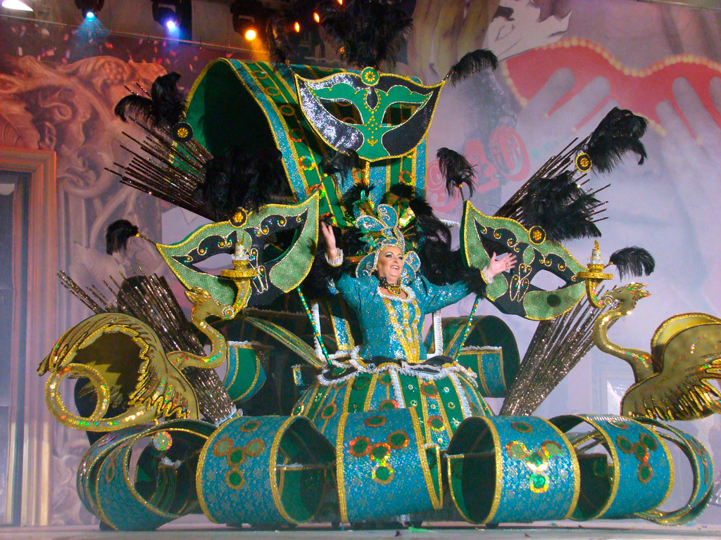 Persoon in kleurrijke kostuum met maskers en veren tijdens het carnaval op Tenerife.