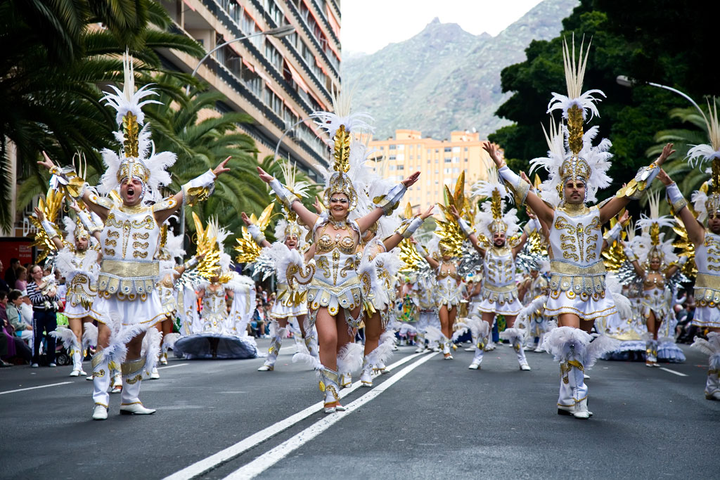 Carnavalsparade in Santa Cruz de Tenerife met witte en gouden kostuums.
