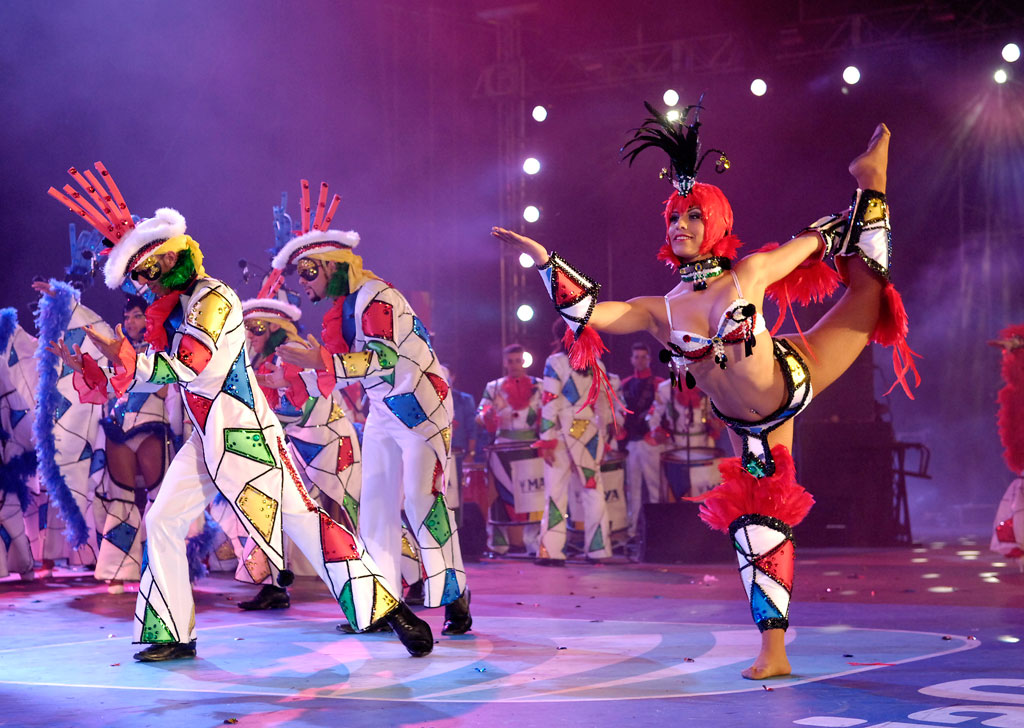 Dansers in kleurrijke kostuums die optreden op het carnaval van Tenerife.