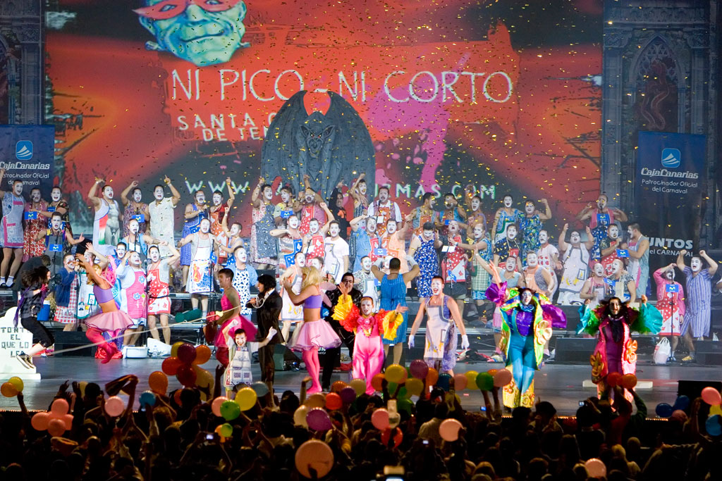 Mensen in kostuum op het carnaval van Santa Cruz de Tenerife. Bevat de tekst NOCH PICO NOCH CORTO.