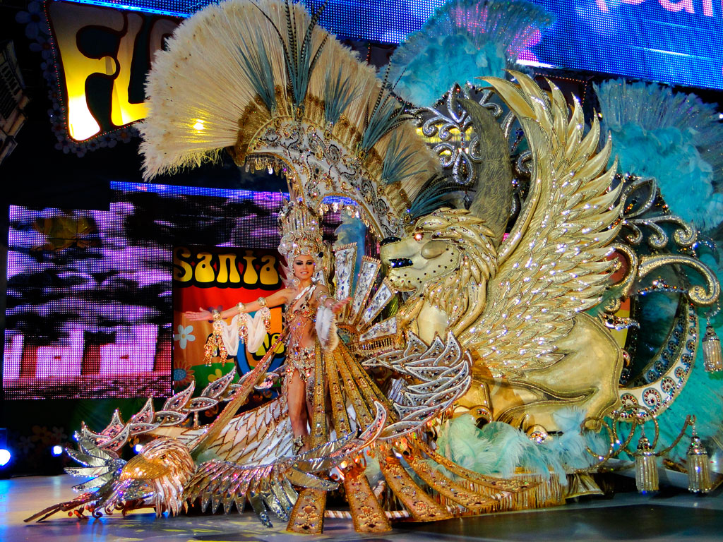 Figuur in een gouden feestelijk kostuum met verenornamenten en gevleugelde leeuw in Santa Cruz de Tenerife.
