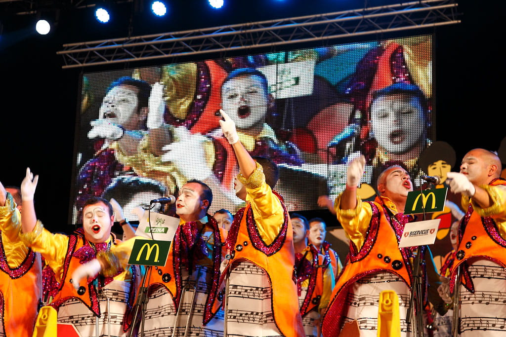 Muzikale uitvoering tijdens een carnaval op Tenerife met kleurrijke kostuums en groepszang.