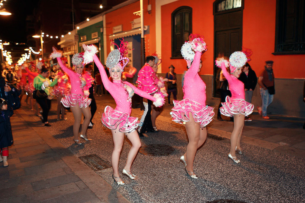 Dansers in roze kostuums paraderen op een nachtkermis op Tenerife.