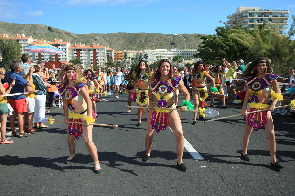 Mensen in kostuums dansen in een parade op de hoofdstraat van Los Cristianos, Tenerife.
