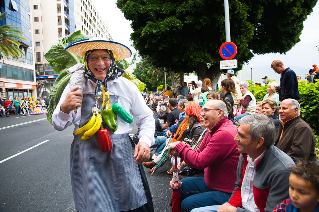 Viering in Santa Cruz de Tenerife met een man in kostuum die het publiek opvrolijkt.