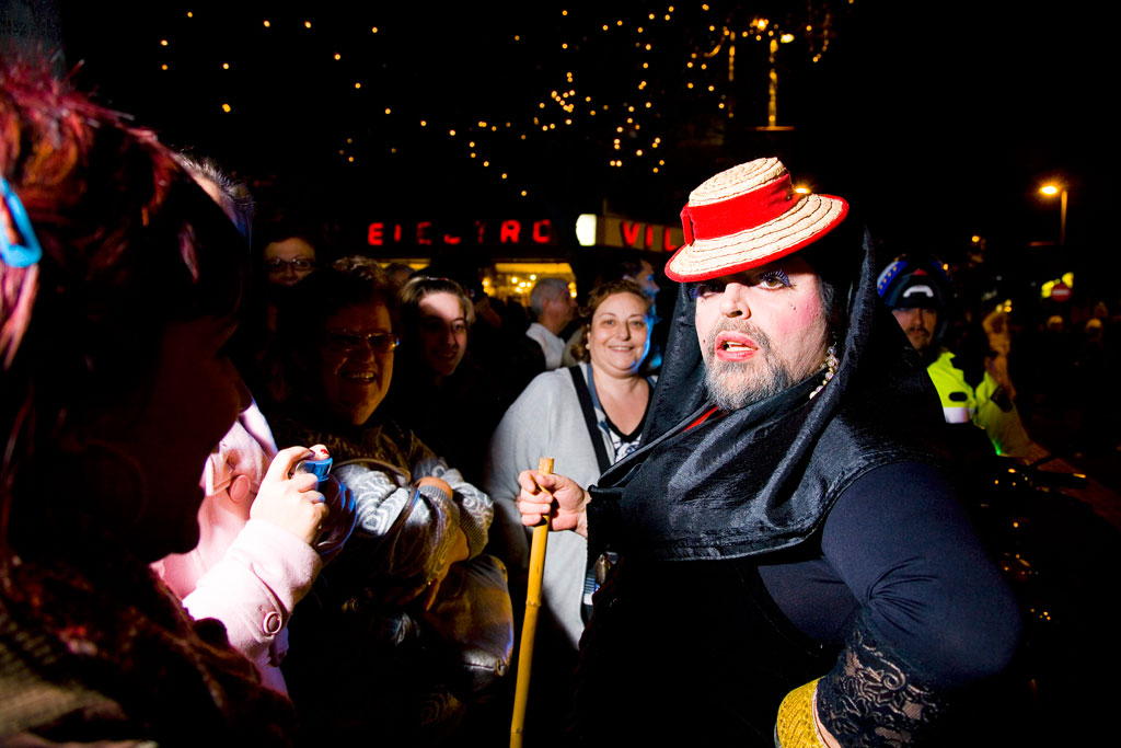 Persoon in kostuum en groep die 's nachts feestvieren in Santa Cruz de Tenerife.