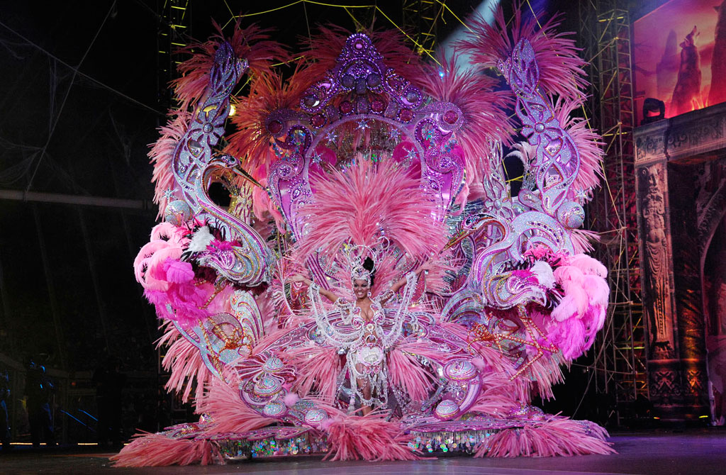 Kleurrijk kermiskostuum met roze veren tijdens een evenement op Tenerife.