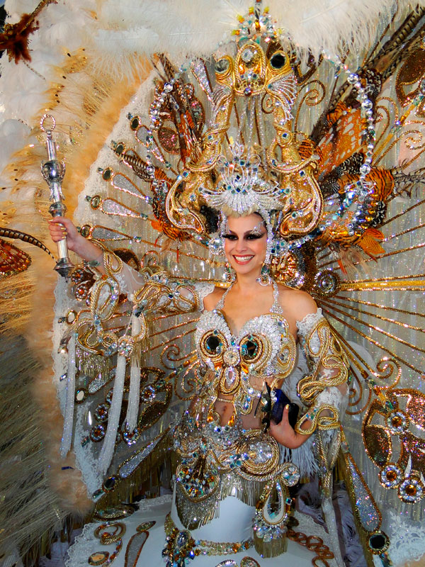 Persoon in kleurrijke en uitgebreide kostuum van het Carnaval van Tenerife, met een scepter in zijn hand.