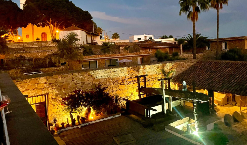 Verlichte binnenplaats met stenen muren en groen in een huis op Tenerife.