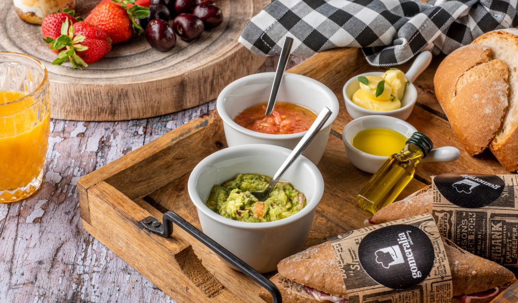 Ontbijt met fruit, sinaasappelsap, guacamole, brood en olijfolie op Tenerife.
