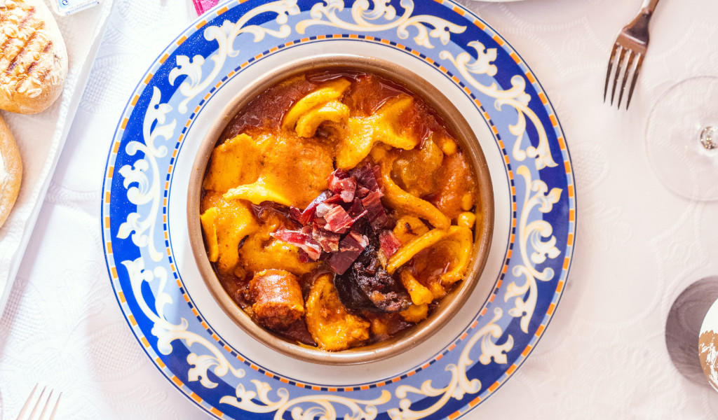 Tenerife-stoofpot met kikkererwten op een decoratief bord, geserveerd aan tafel.