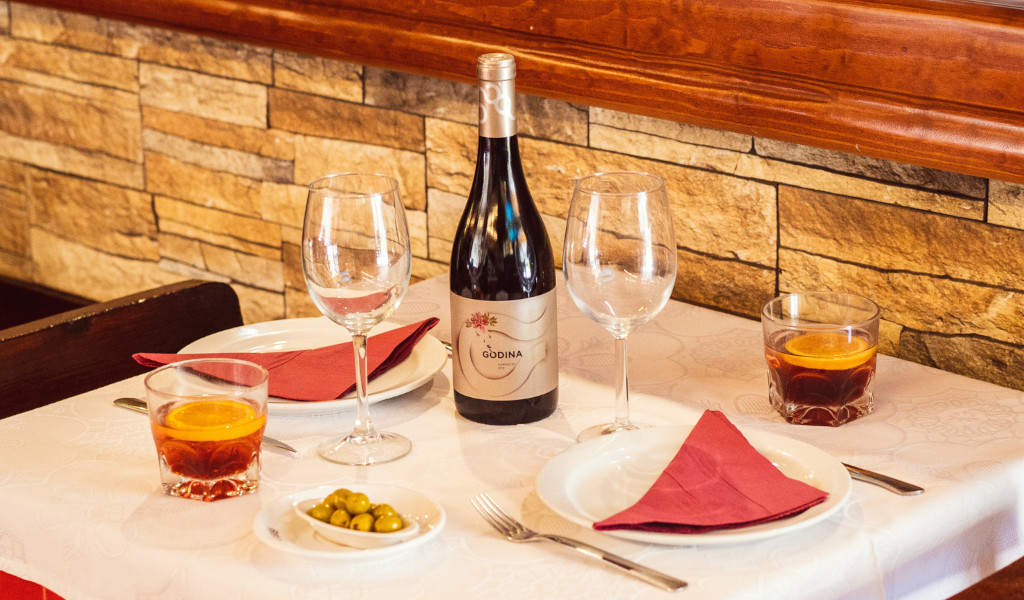 Tafel in een restaurant op Tenerife met glazen, een fles gondelwijn en glazen met drankjes.