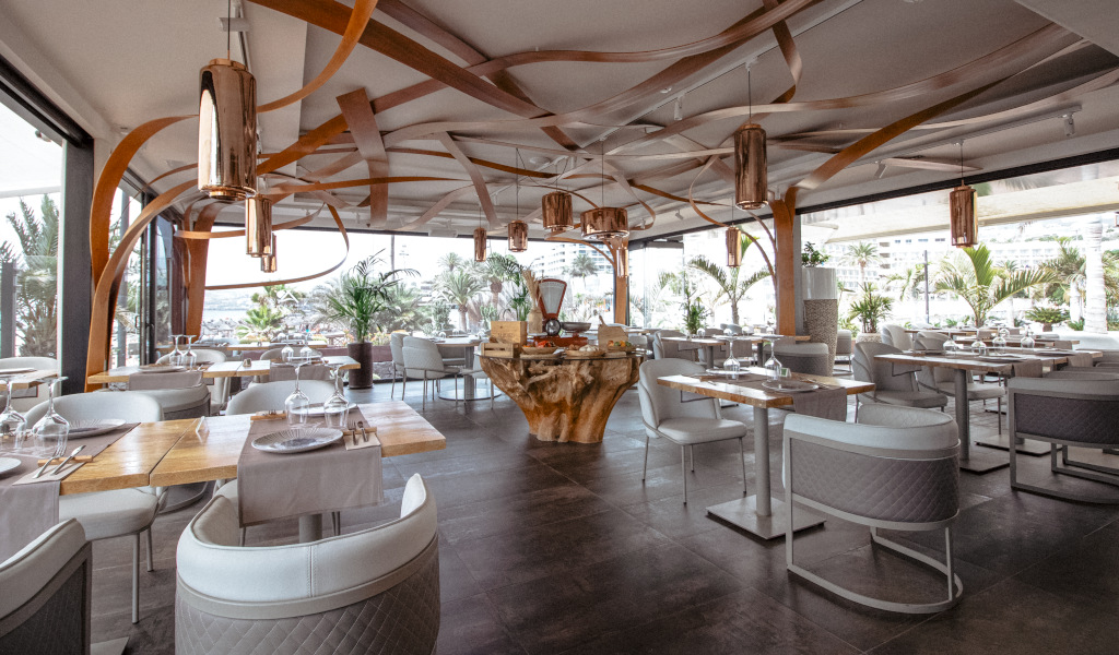 Modern restaurant met elegante inrichting op Tenerife, tafels bij grote ramen.