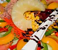 Salade met ananas, geraspte wortel, maïs en decoratieve saus op Tenerife.