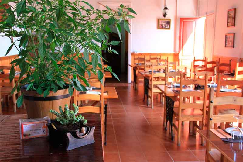 Restaurant op Tenerife met houten tafels en stoelen, decoratieve plattegrond op de voorgrond.