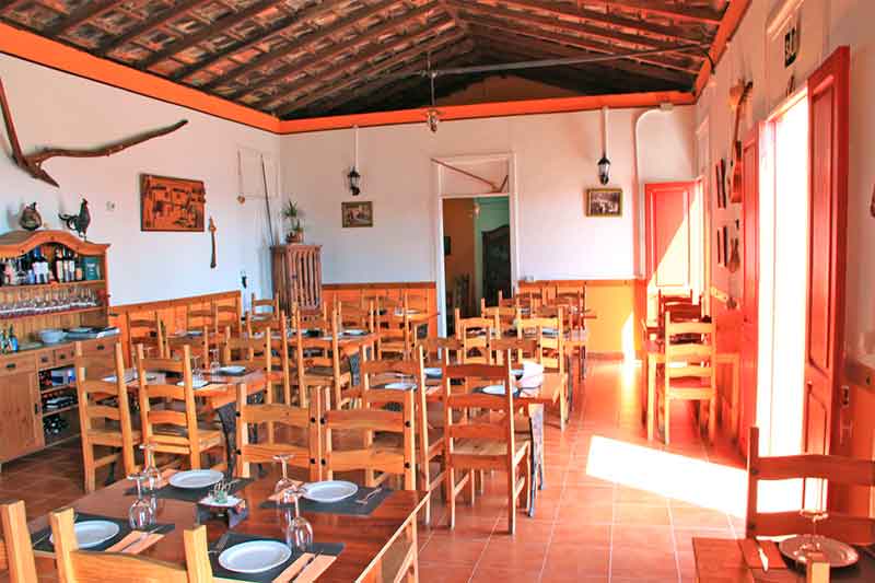 Rustiek restaurant op Tenerife met houten tafels en stoelen opgesteld.