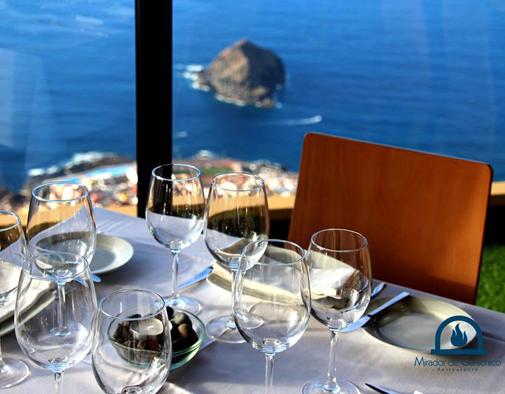 Tafel met glazen en borden, zeezicht vanaf de Mirador de Garachico, Tenerife.