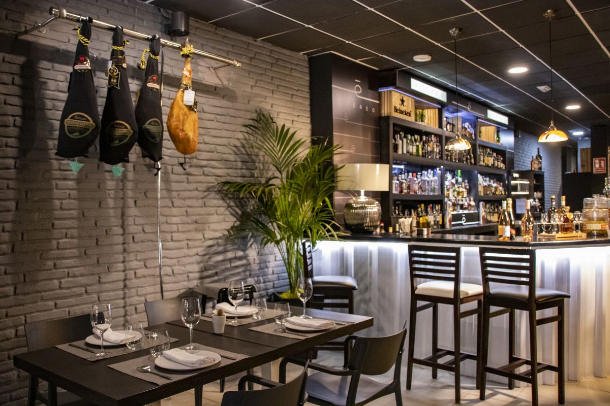 Bar met hangende hammen en een tafel klaargemaakt in een restaurant op Tenerife.
