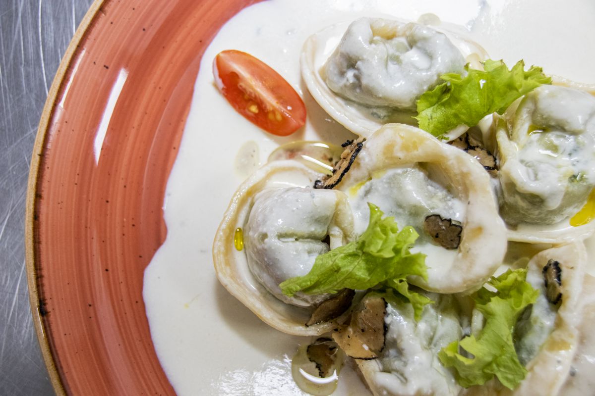 Tortellini met truffel en sla in witte saus, gepresenteerd op een bord op Tenerife.