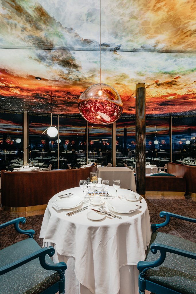 Tafel met glazen en servies onder een beschilderd plafond in een restaurant op Tenerife.