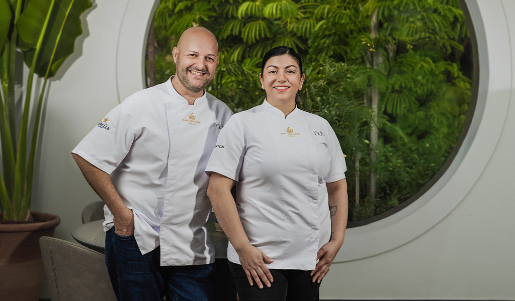 Twee chefs die glimlachen in witte uniformen voor een tuin op Tenerife.