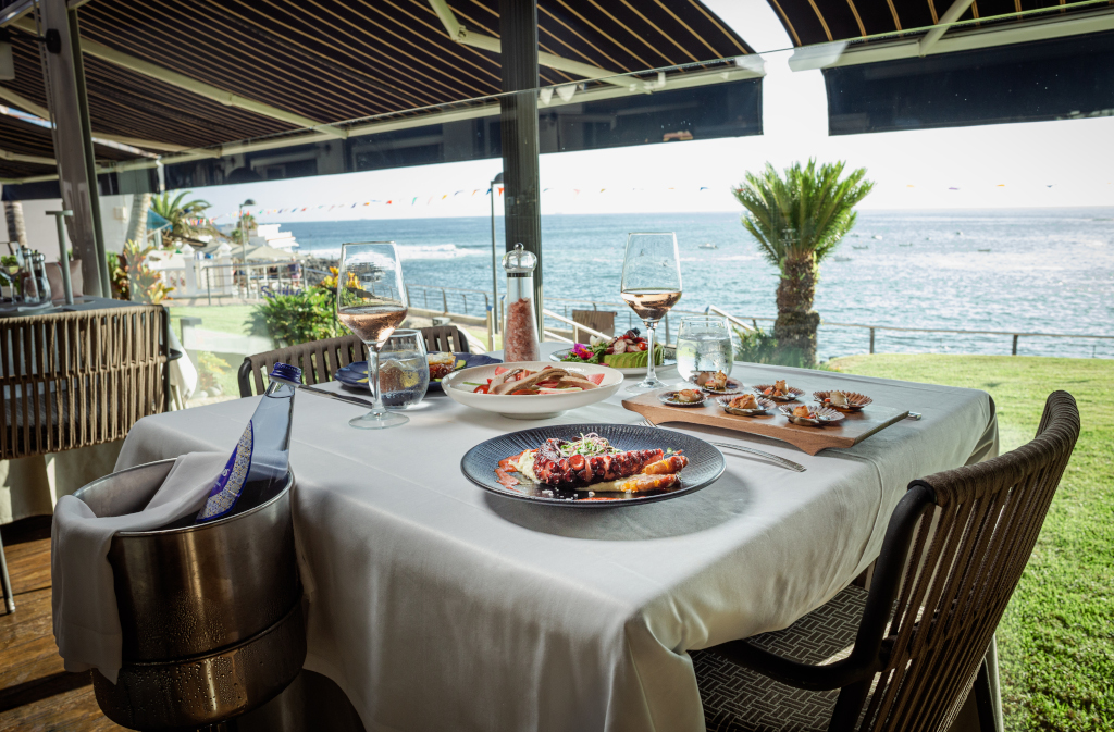 Restauranttafel met gastronomische gerechten en zeezicht op Tenerife.