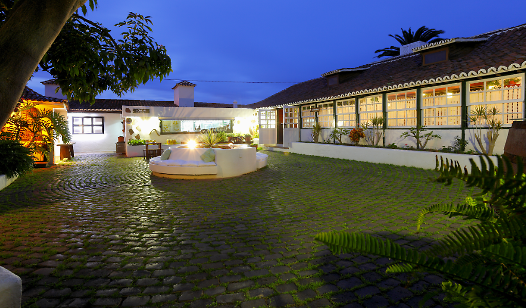 Verlichte binnenplaats van een traditioneel huis op Tenerife bij schemering.