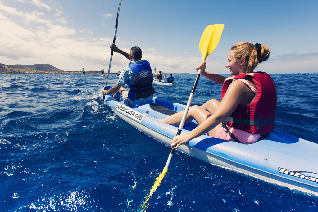 Mensen peddelen kajaks in de zee nabij de kust van Tenerife.