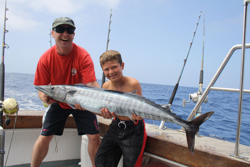 Mensen die een grote vis vasthouden op een vissersboot op Tenerife.