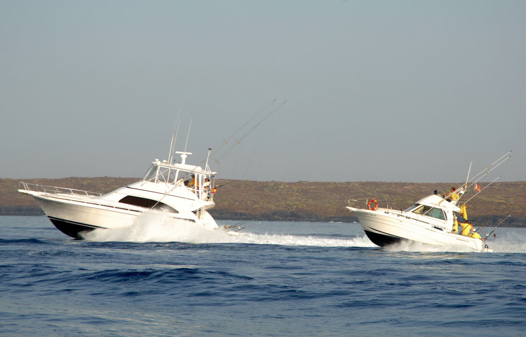 Boten varen op zee bij Tenerife met mensen aan boord.