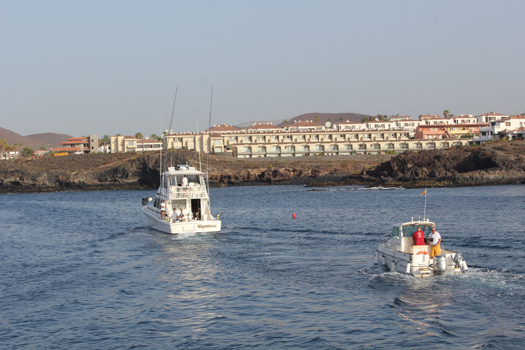 Boten op zee nabij de kust op Tenerife, met gebouwen op de achtergrond.