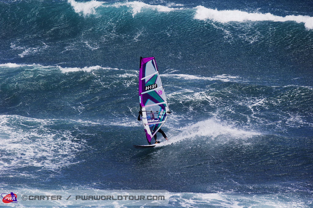Iemand die windsurft op grote golven op Tenerife. Zichtbare tekst: H13