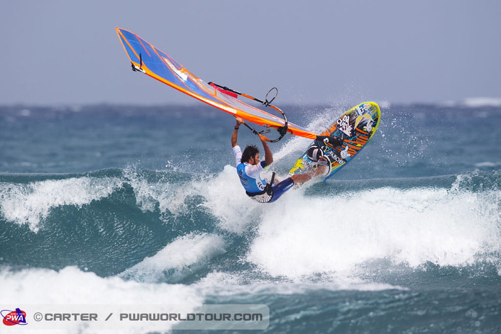 Persoon die windsurft op een golf in El Médano, Tenerife.