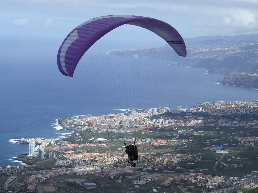 Paraglidingvliegen over de kust van Tenerife met de Atlantische Oceaan op de achtergrond.