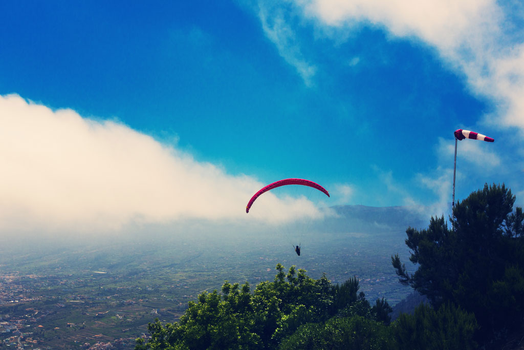 Paragliden in de lucht van Tenerife boven een bergachtig landschap?