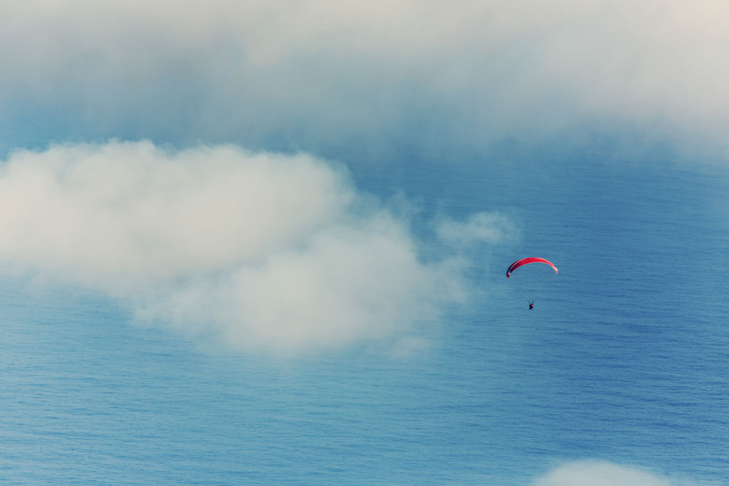 Paragliden over de oceaan op Tenerife tussen verspreide wolken.