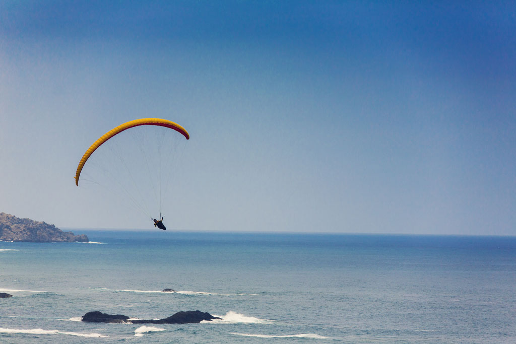 Paragliden over de kust van Tenerife met de oceaan op de achtergrond.