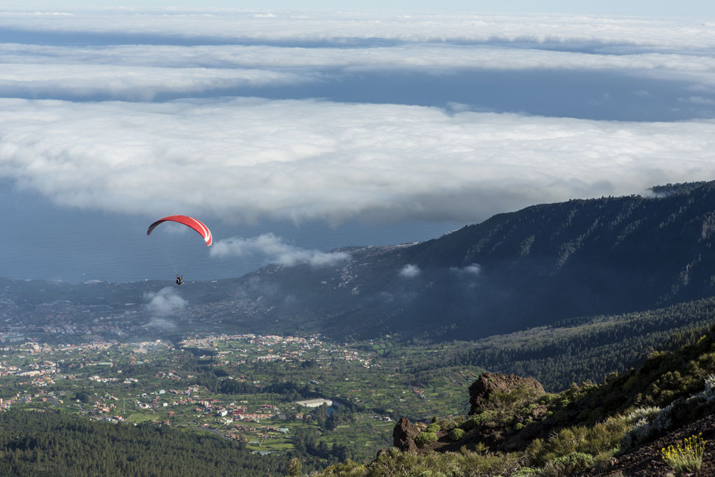 Paragliding over de vallei op Tenerife met lage wolken.