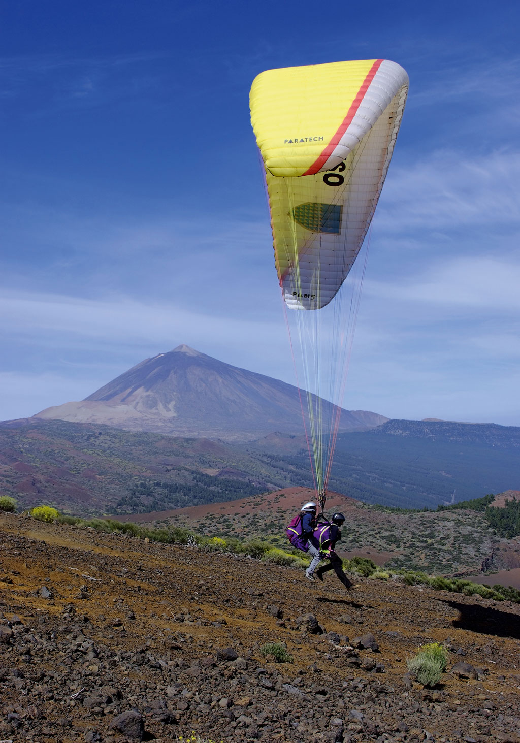 Paragliding over het landschap van Teide op Tenerife met twee piloten.